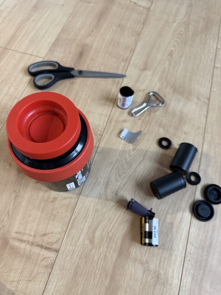 Die Jobo-Dose offen, daneben Spirale, ein RPX 400 und die herausgezogene Filmlasche.